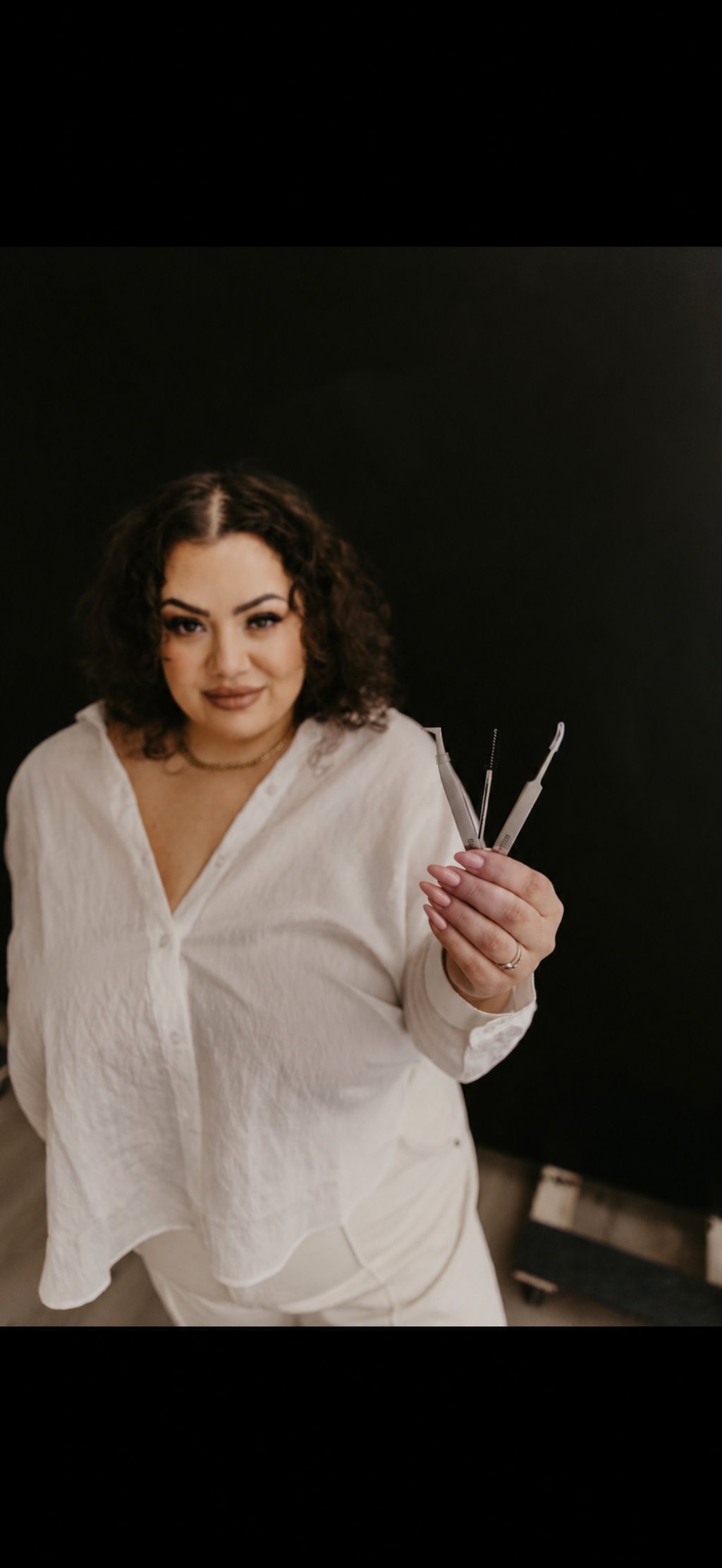 Char, owner and lash artist at Chars Lash Bar, holding lash tools